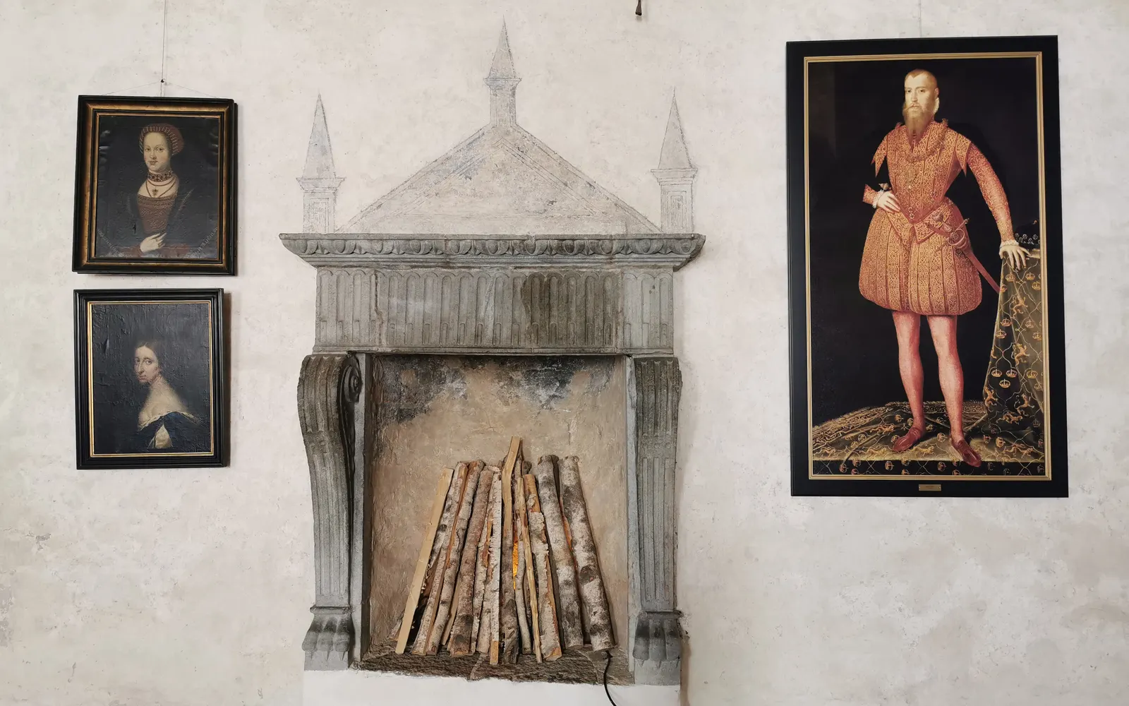 A fireplace and portraits in a room at Kalmar Castle
